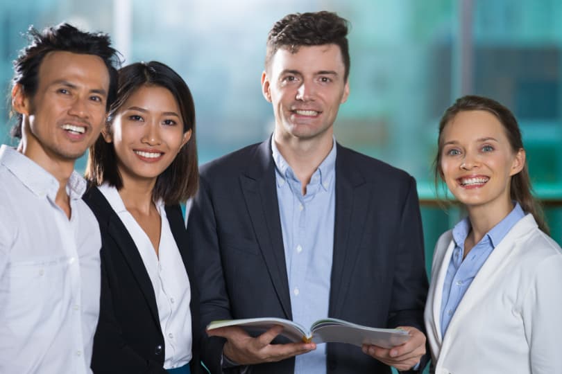 a-group-of-business-professionals-smiling-while-holding-a-book