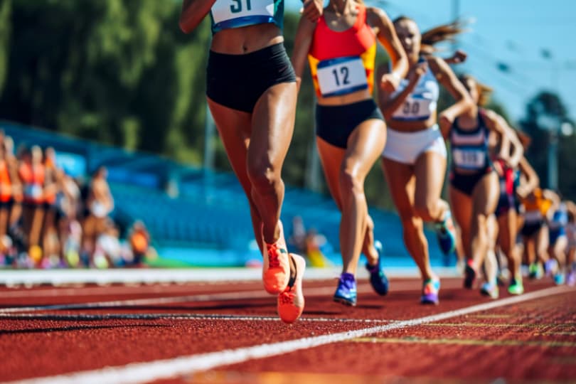 a-group-of-female-athletes-sprinting-on-a-track